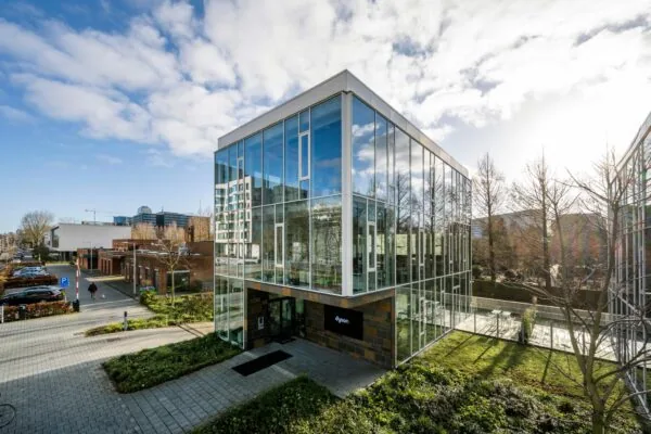 Modern kantoorgebouw met glazen gevel aan de Fred. Roeskestraat in Amsterdam, met het logo van Dyson bij de ingang.
